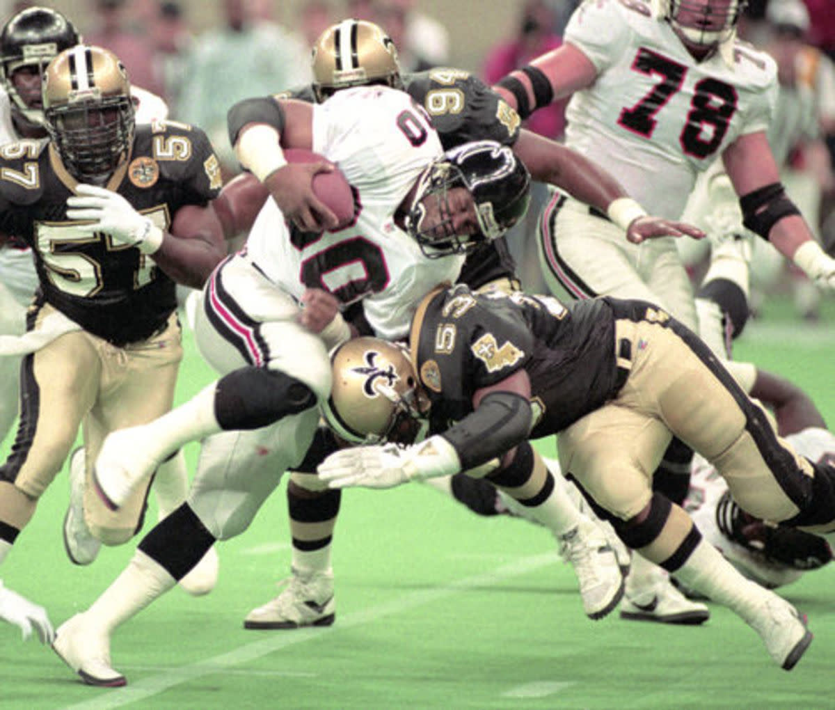 Saints LB Vaughan Johnson (53) brings down Atlanta WR Andre Risen (80) in a 1991 Wild-Card matchup. Credit: si.com